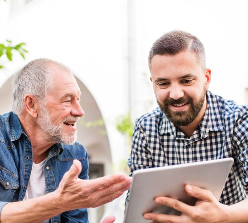 zwei Generationen bei Diskutieren mit Tablet
