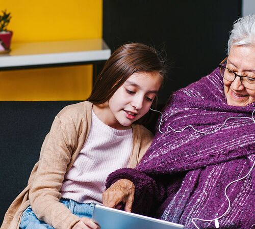Mädchen und Seniorin beim Blick aufs Tablet