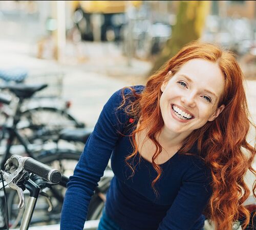 junge Frau beim Abstellen des Fahrrades