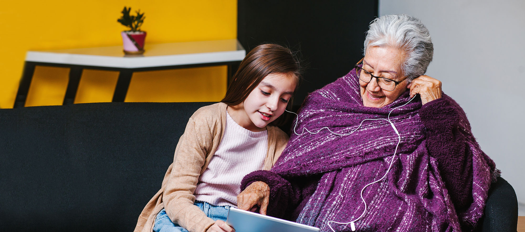 Mädchen und Seniorin beim Blick aufs Tablet